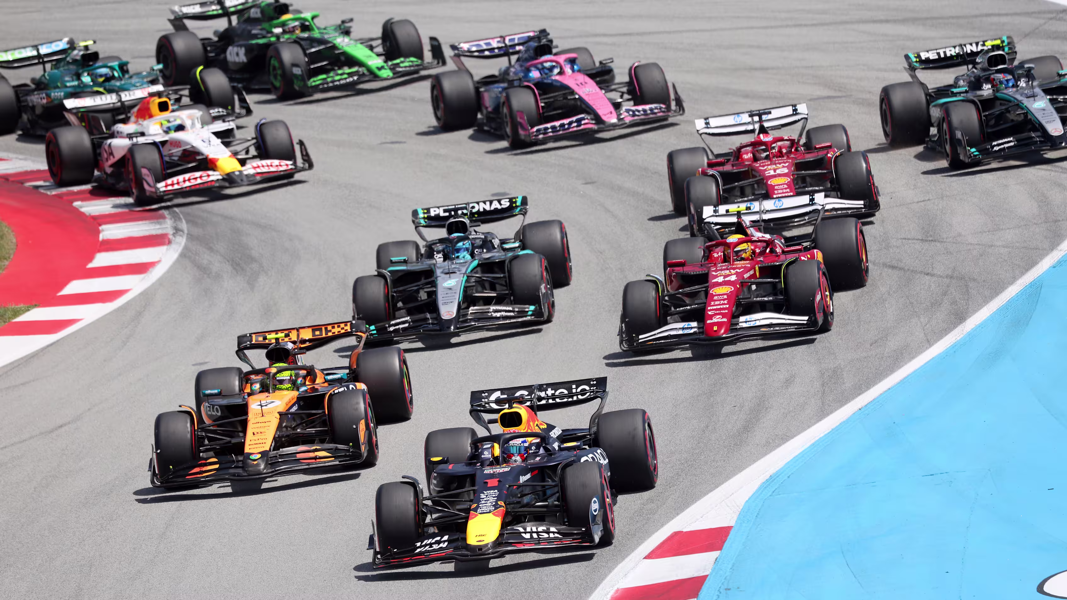 Formula 1 cars are racing on the track.