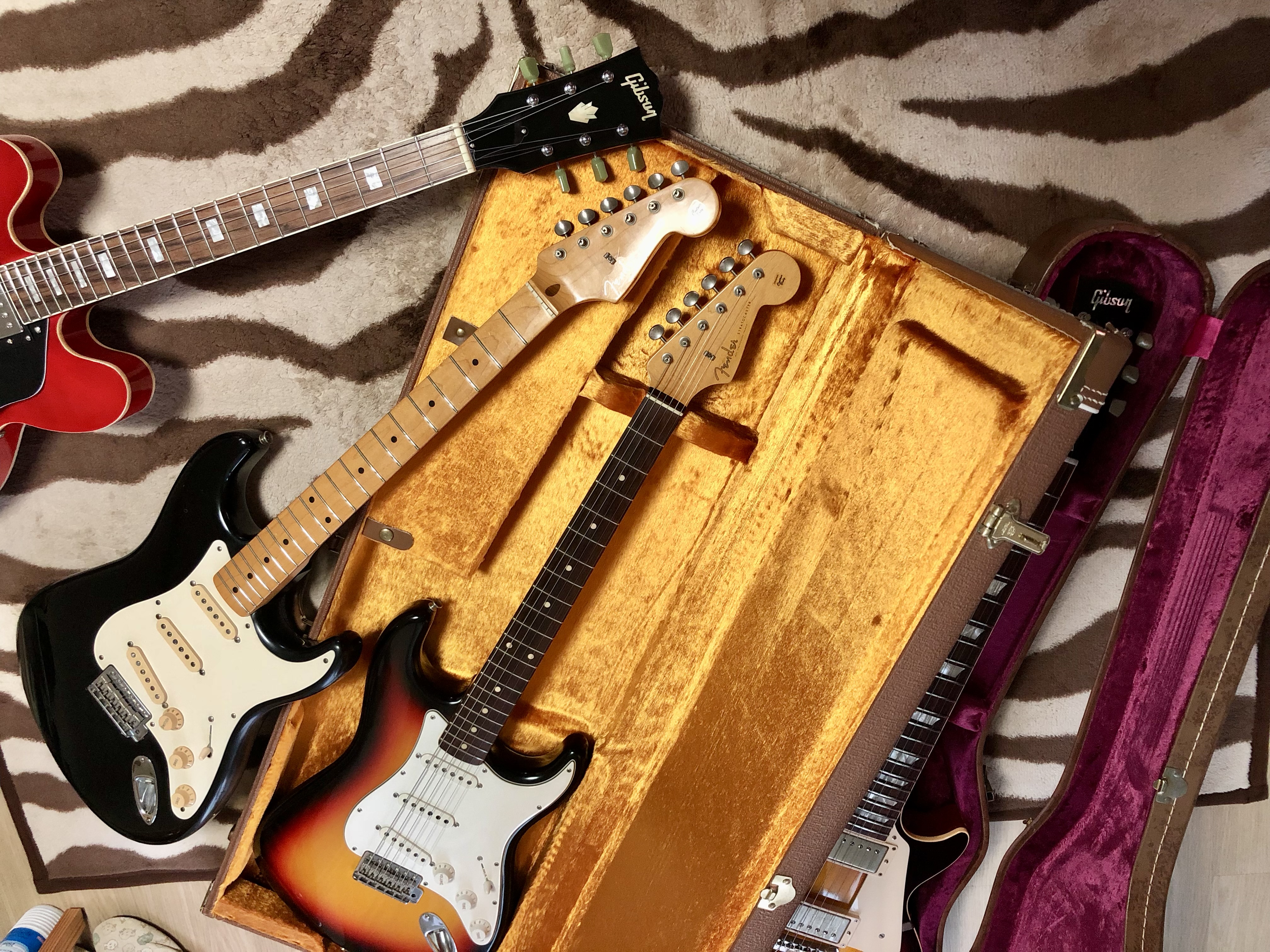 A photo of several guitars gathered together.